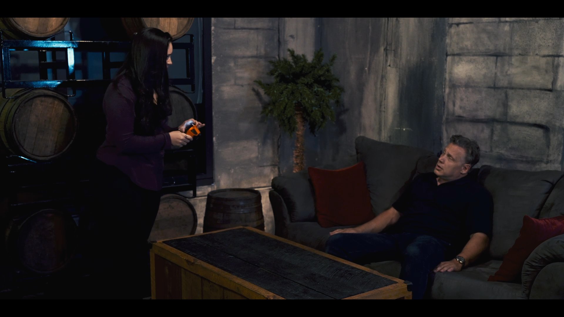 A therapist monitors a client during a structured session, utilizing a handheld device to track information while they engage in a formal discussion.