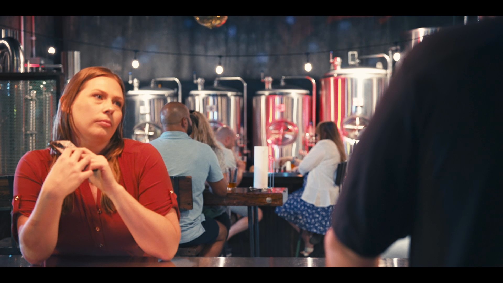Two individuals conduct a professional beverage tasting and evaluation at a brewery, followed by a collaborative discussion and digital data review.