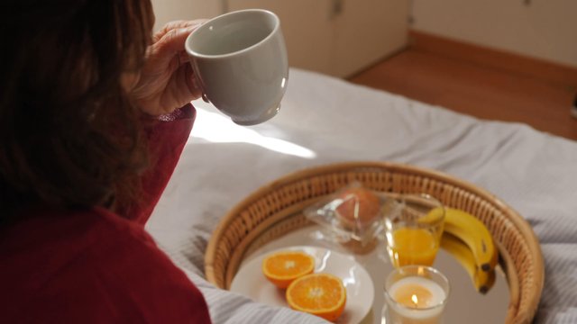 Mother drinking coffee in bed on Mother's Day