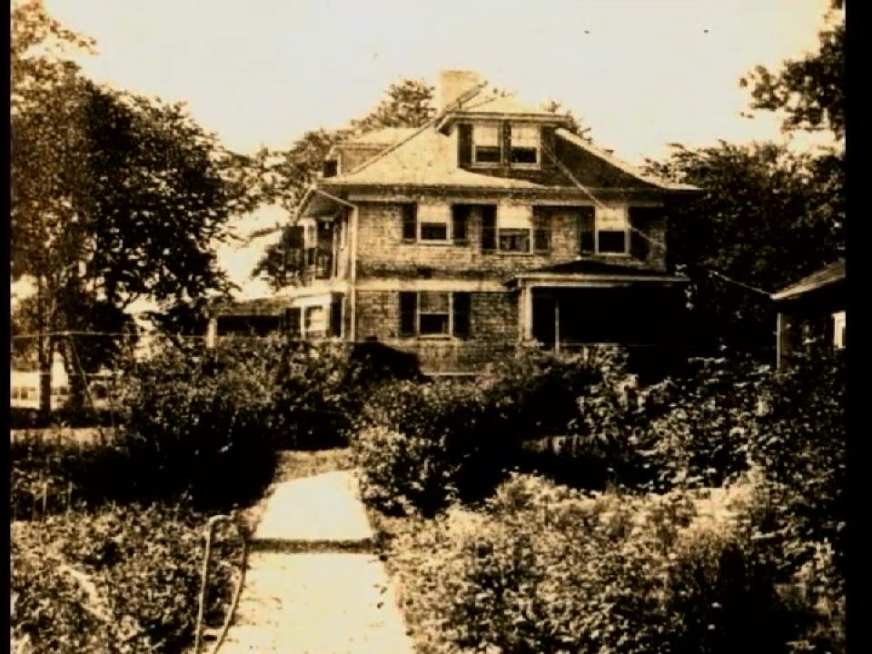 An elderly man shares personal memories, transitioning from vintage childhood photographs to scenes of his family home and historical community footage. This biographical account bridges past and present through preserved visual archives.