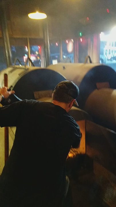 DAS BBQ - Co-owner Stephen Franklin throwing wood in Lefty. - Barbeque Near Me - Atlanta, Georgia