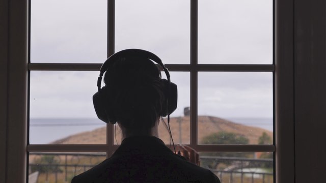 Listening to music by a window