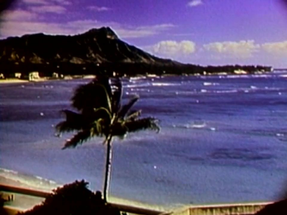 The sequence captures iconic views of Diamond Head overlooking the Pacific Ocean, transitioning to lush, tropical roadways winding through the Hawaiian landscape.