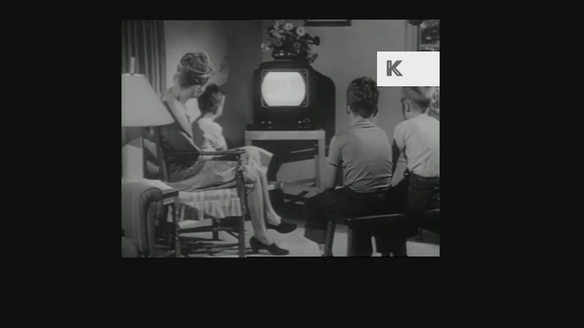 An introduction to the history of reality television features vintage archival footage of a family watching a baseball game on a broadcast television set.