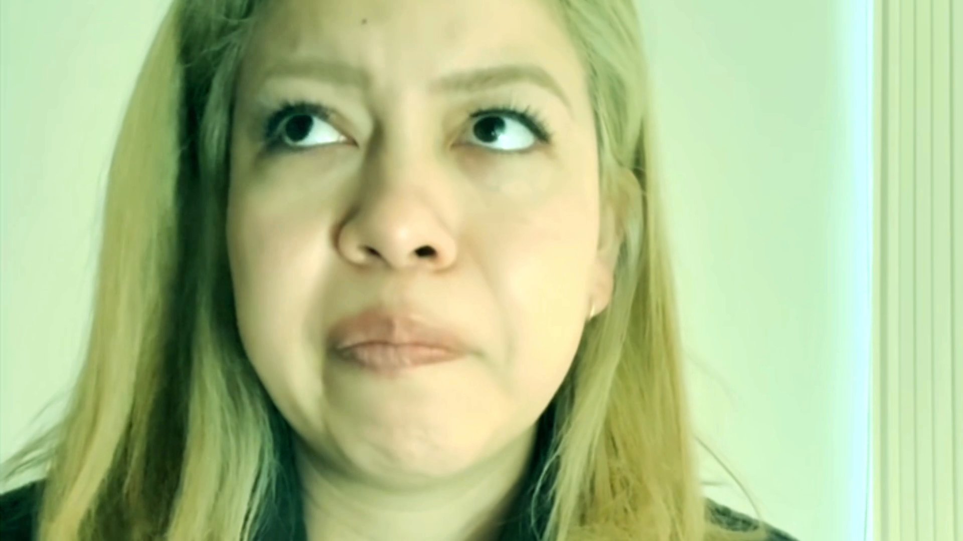 A woman delivers a direct, thoughtful monologue, showing a range of expressive facial reactions while she speaks.