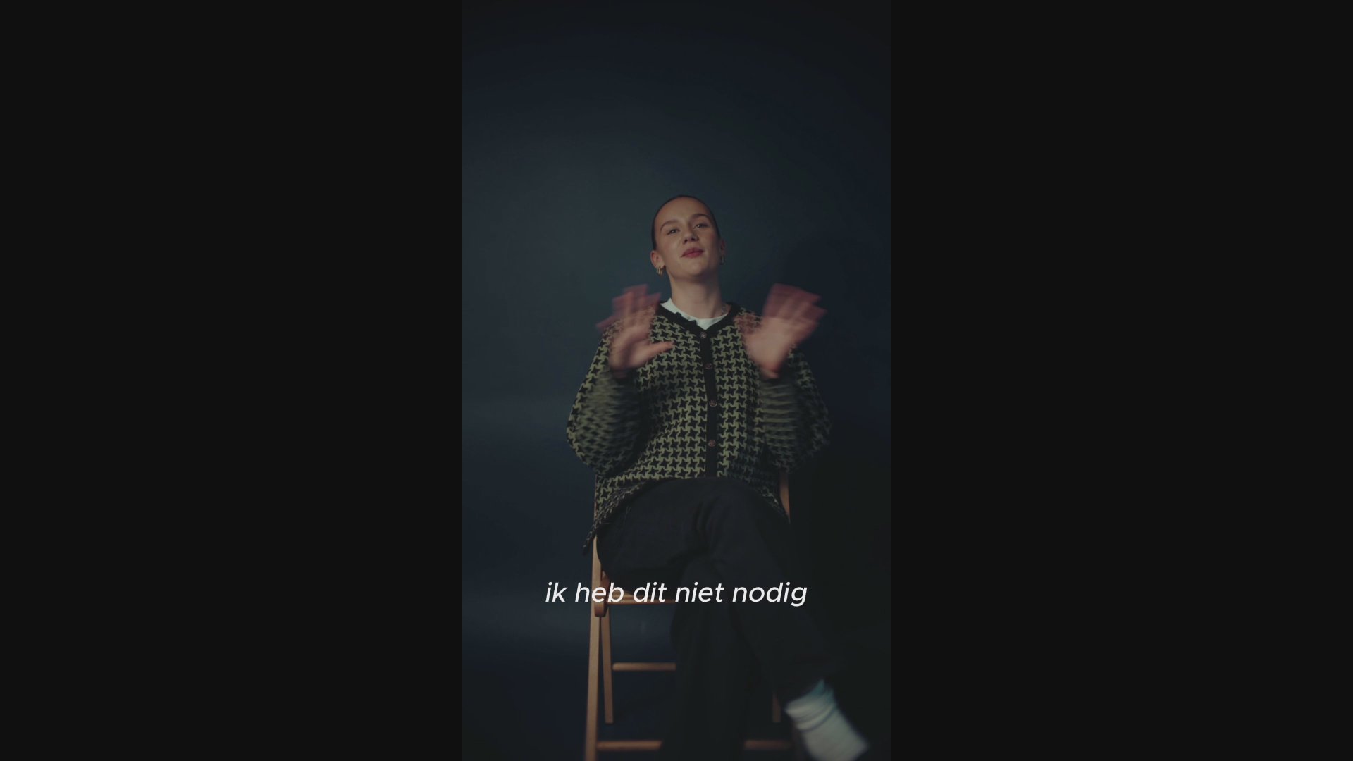 Filmpje van Emily die zit op een stoel en haar verhaal voor de camera vertelt