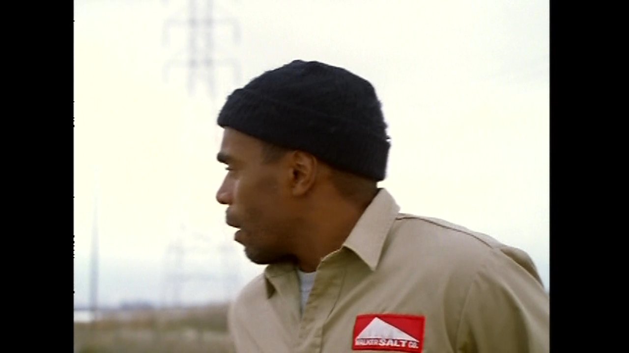 A woman exhibits visible distress during a tense interaction on a desolate roadside. The sequence concludes with the pair sharing a quiet, somber meal in a dining room.