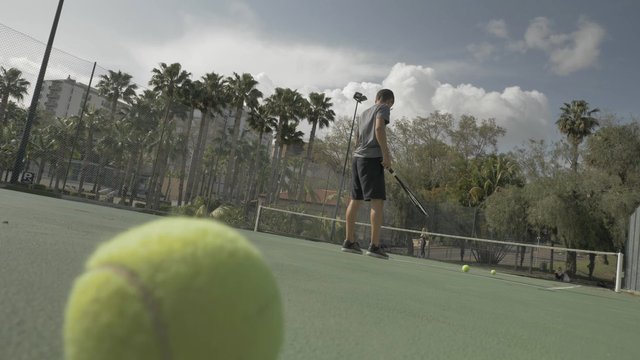 Man bouncing a tennis ball before serving