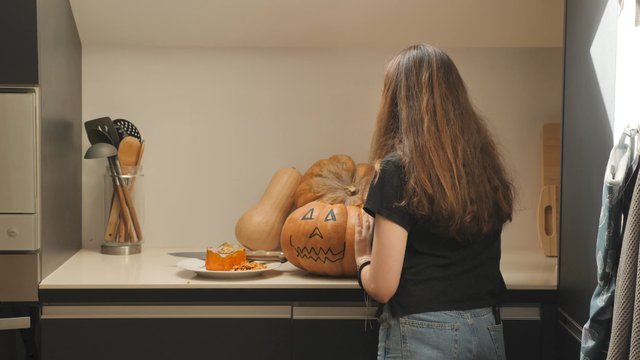 Girl pulling out pumpkin seeds