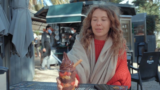 A girl eating chocolate ice cream at a street café