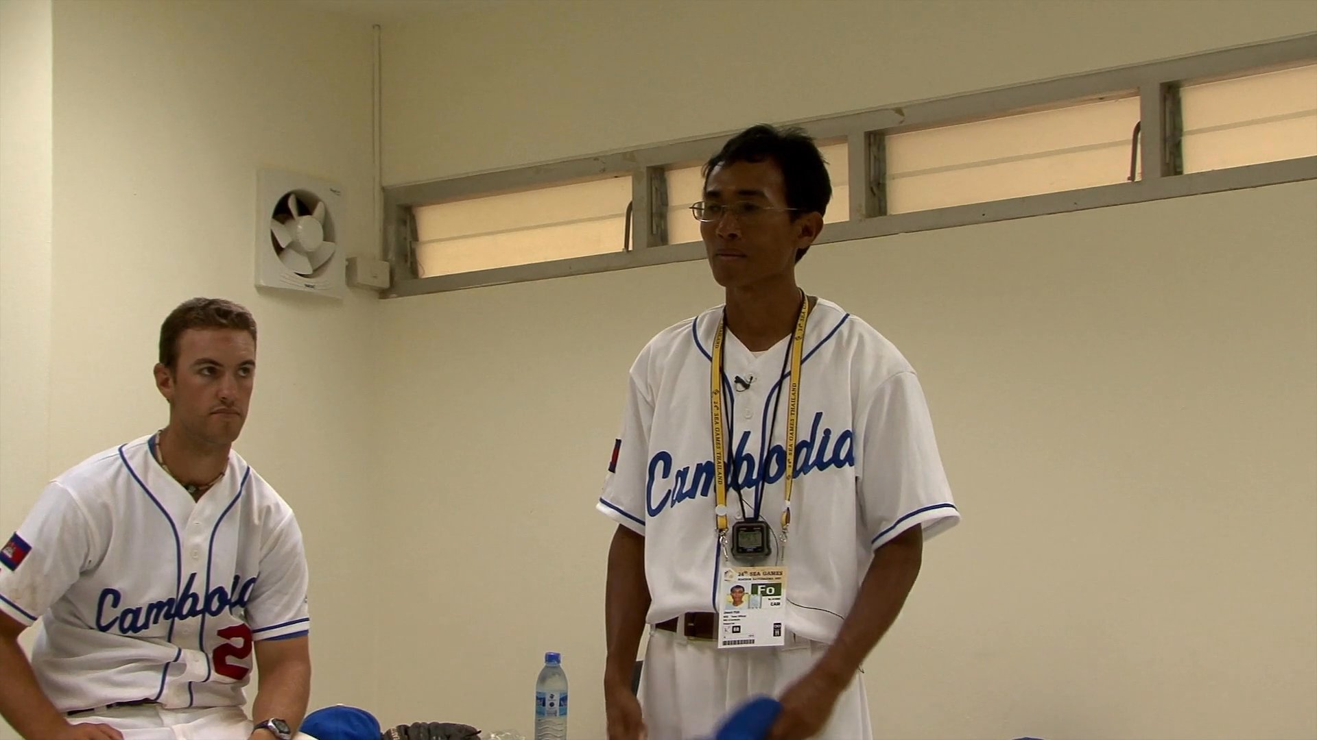 A coach provides constructive feedback and motivation to his baseball team in a locker room setting. He discusses recent game performance, highlights team effort, and expresses satisfaction with their collective progress.
