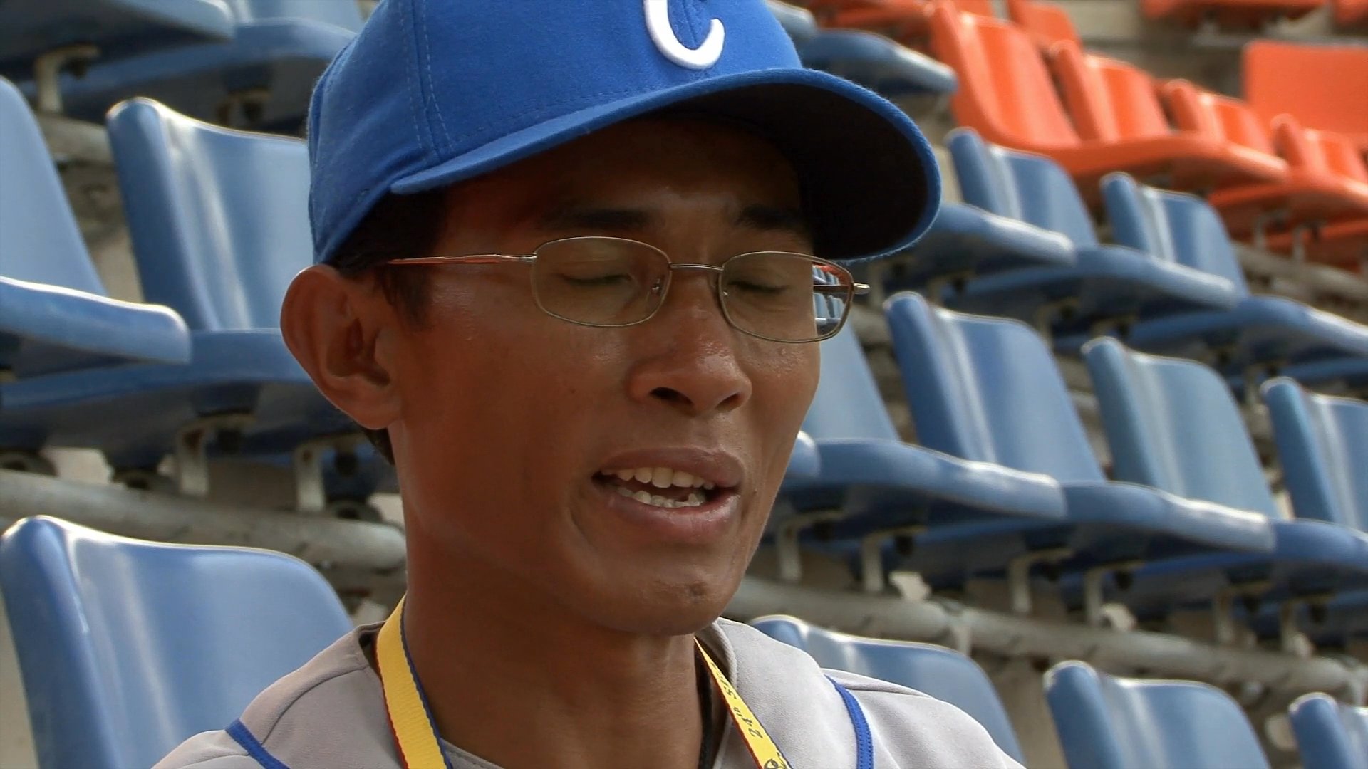 A baseball coach delivers a message of encouragement and resilience to his team while seated in an empty stadium.