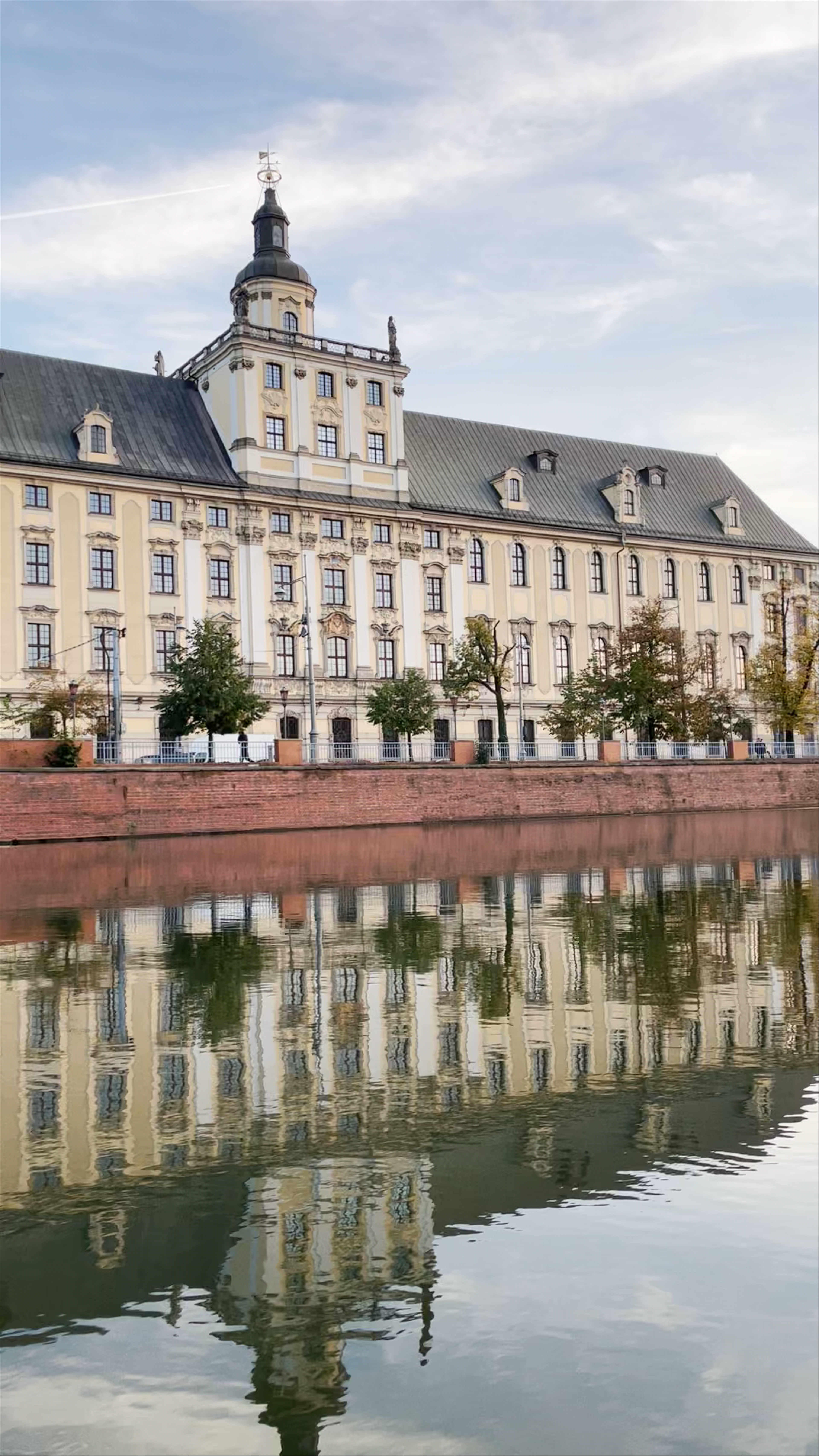 Historic Uniwersytet Wrocławski Reflecting Serenity by the River in Wrocław