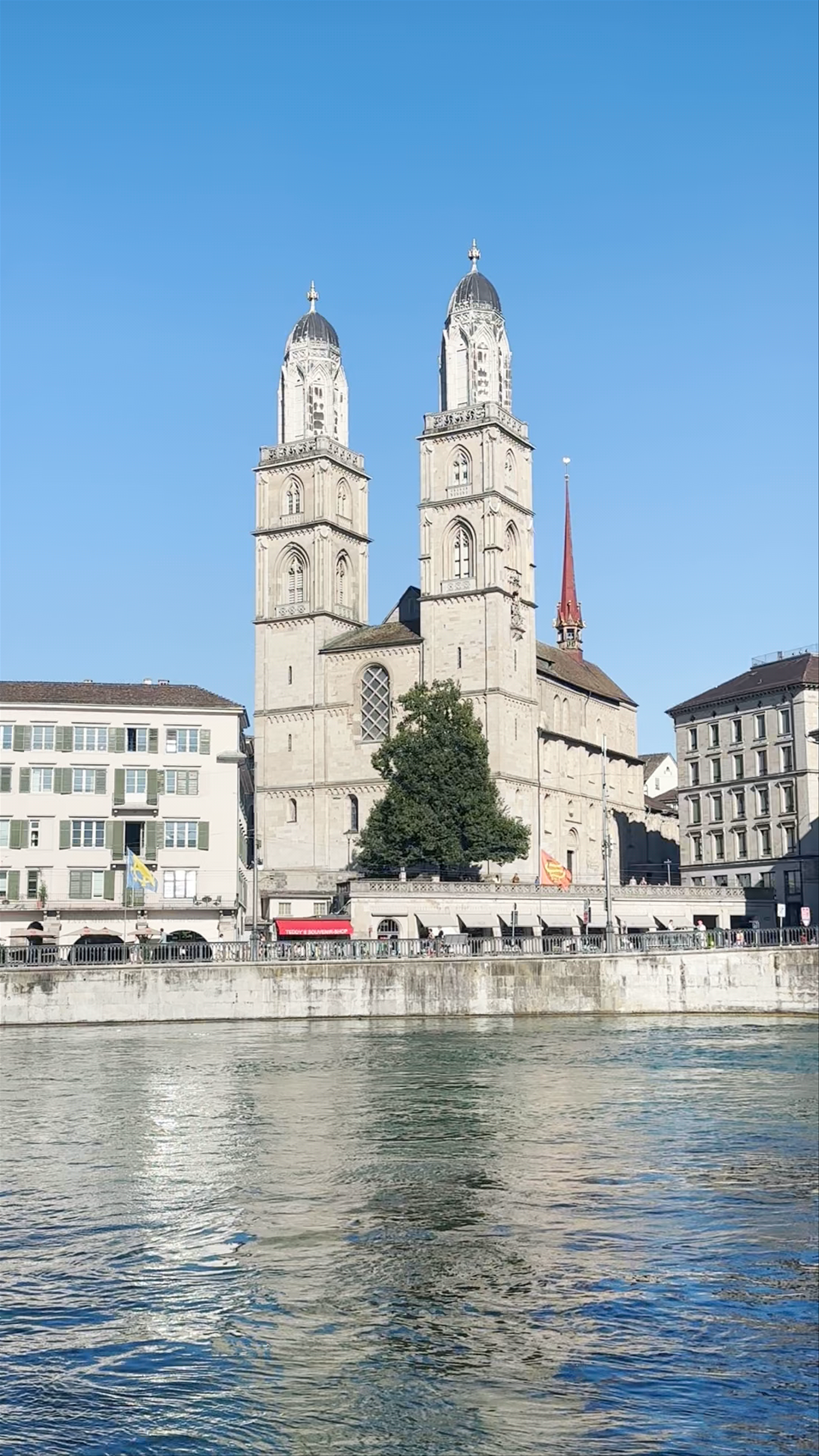 Sunlit Zurich: Iconic Grossmünster Cathedral and Riverfront Stroll