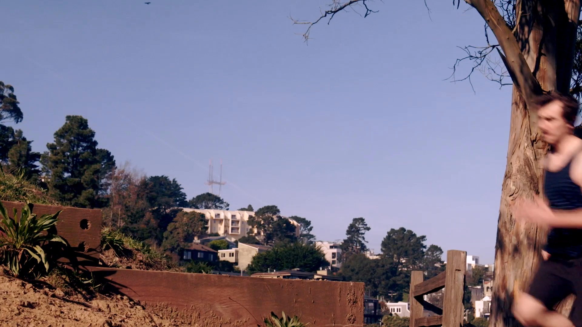 An athlete performs high-intensity cardiovascular training by running up a long set of outdoor stairs in a hillside urban park. The session highlights athletic endurance and rigorous physical exercise in an outdoor environment.