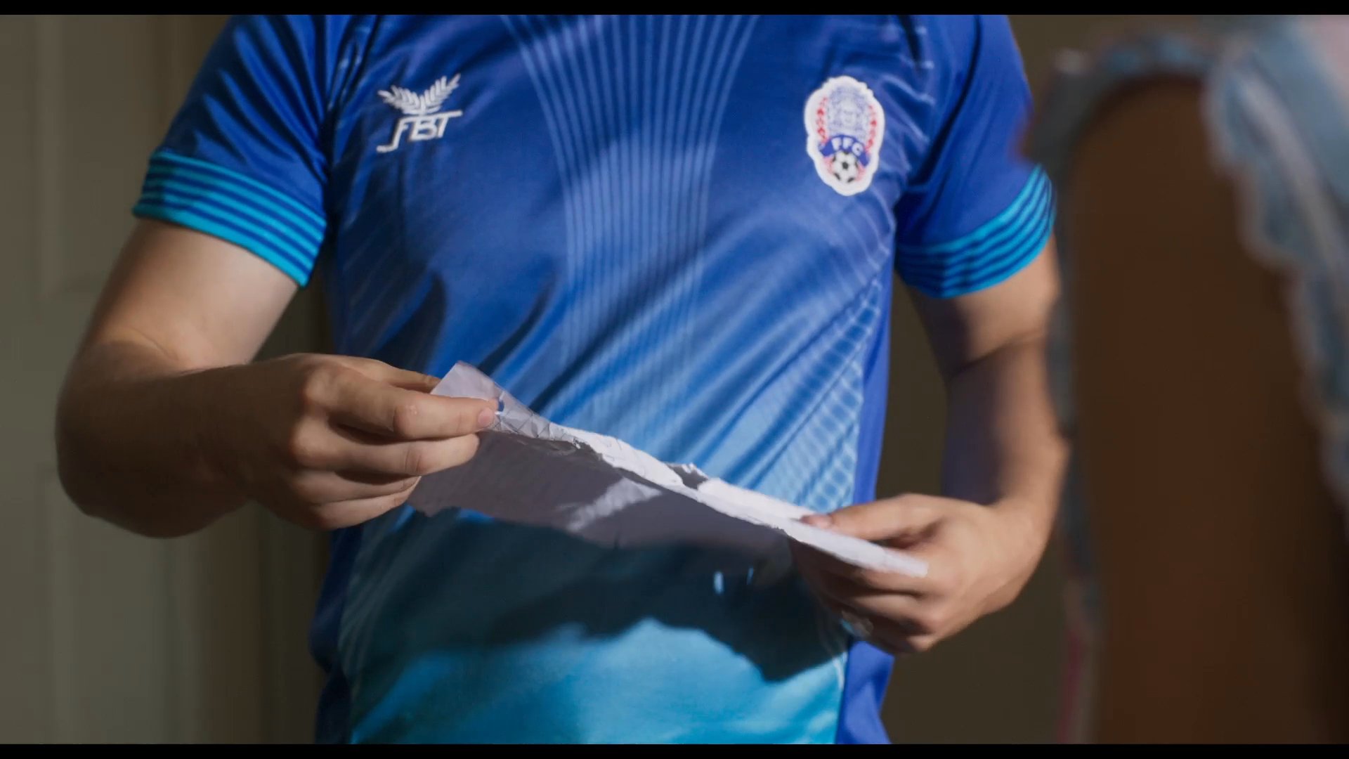 A mother and her teenage son experience a tense interpersonal exchange within a domestic setting. The interaction centers on a written note as they discuss private matters.