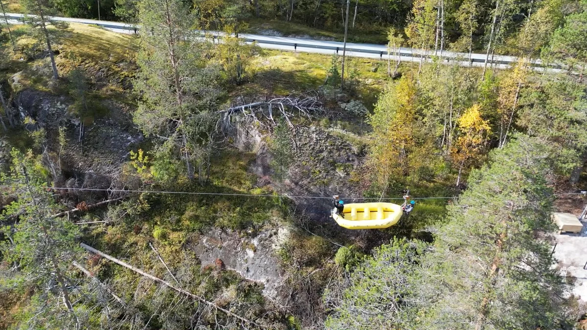 People rafting in clear blue water and ziplining over it.