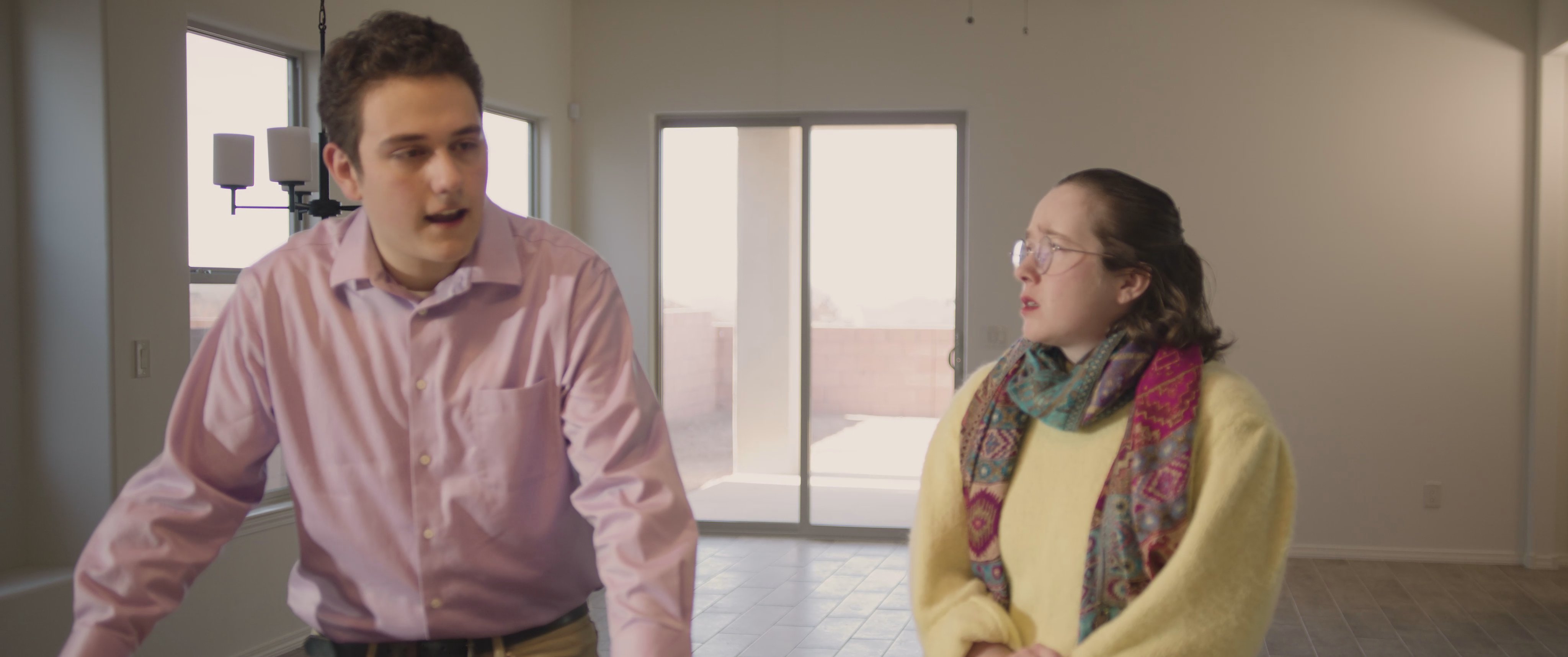 A group of individuals examines the kitchen area of a home, discussing details of the property during an indoor walkthrough.