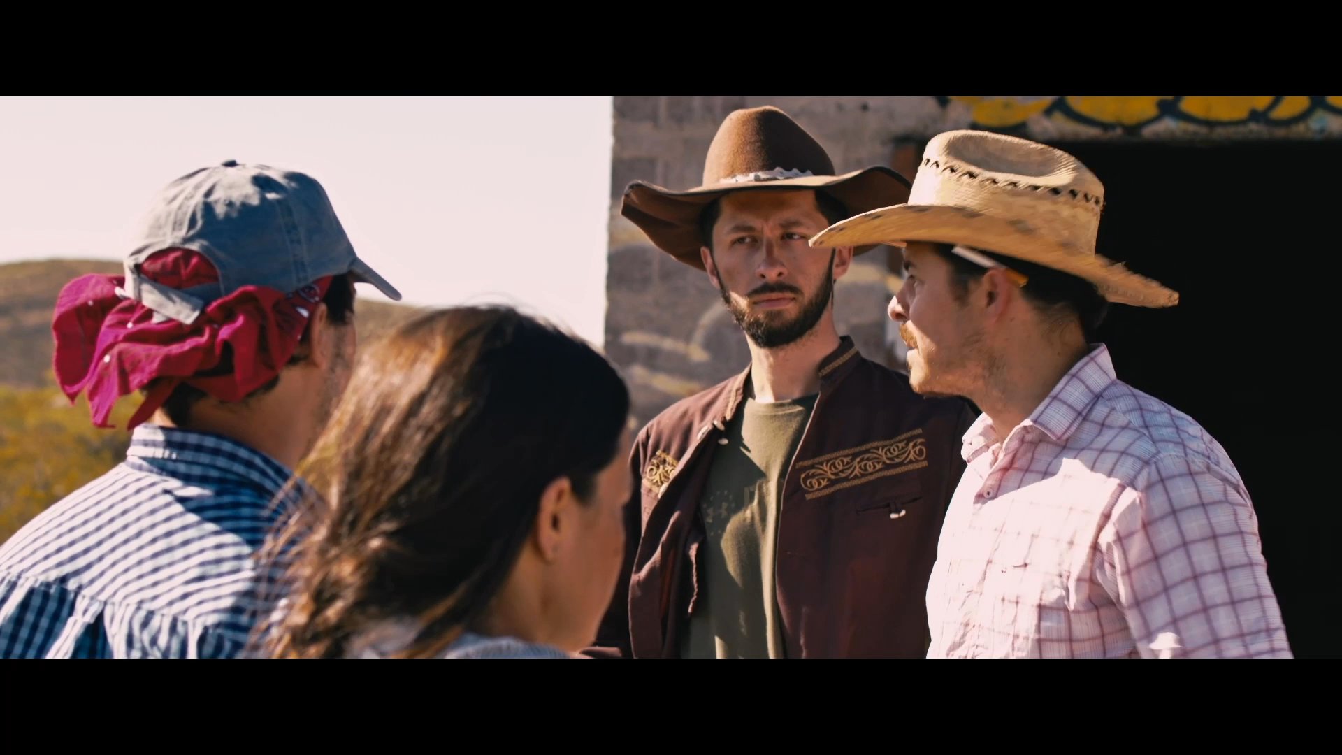 A group of individuals engages in a heated dispute in a desert setting, with one party accusing another of robbery. The tension escalates as the accused denies the allegations while the group continues to debate the truth.