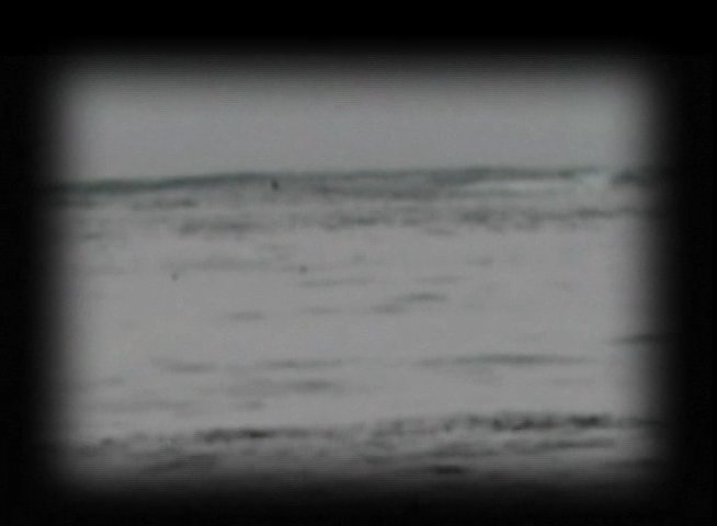 Powerful ocean waves roll toward a shoreline featuring a wooden pier, transitioning to a vintage photograph of a large steamship docked with spectators nearby.