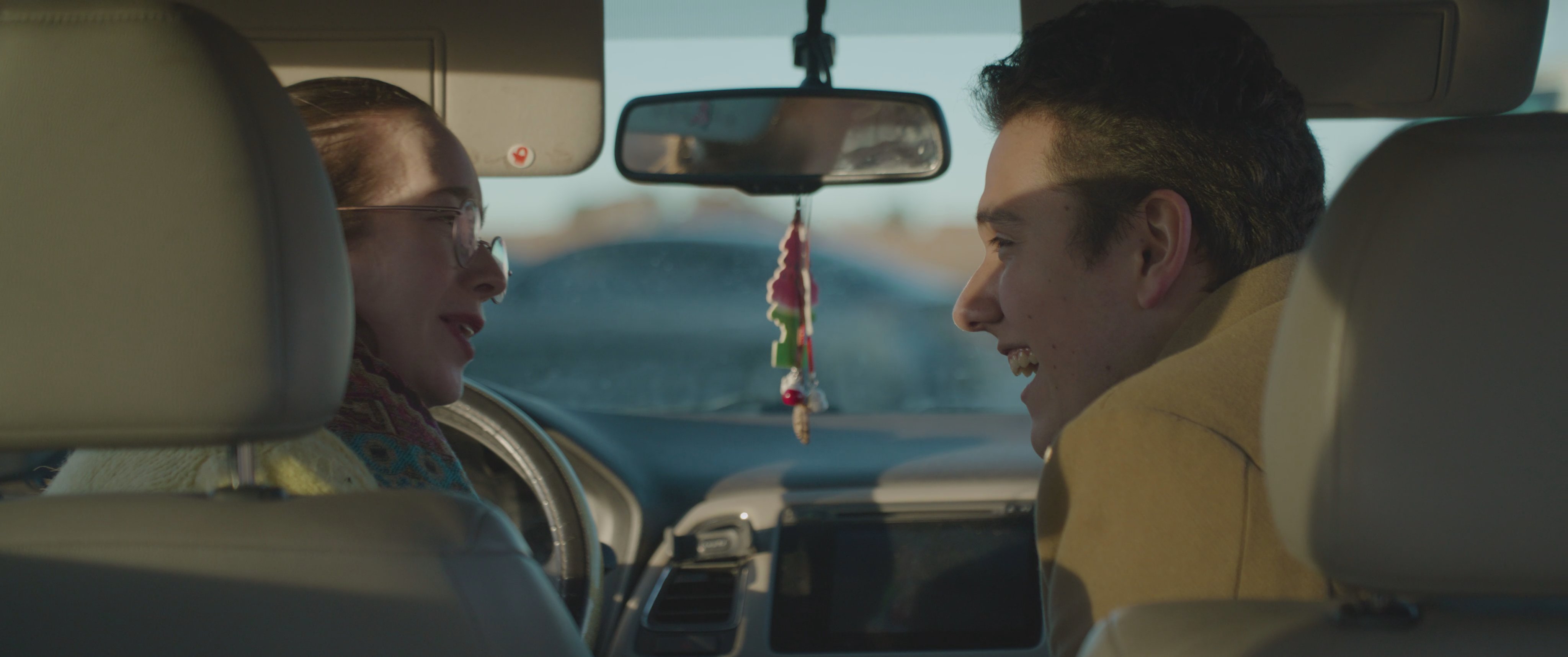 A man and a woman share an intimate moment and a warm embrace while parked inside a vehicle. They exchange parting words before the man exits, marking a sentimental farewell.