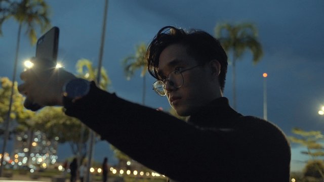 Man taking a selfie on the street at night