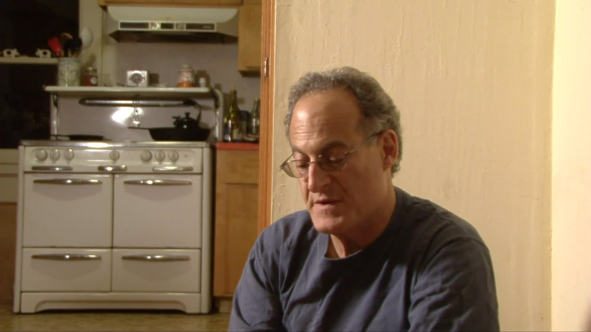 A man shares a quiet, affectionate moment with his black labrador in a kitchen before transitioning to an outdoor setting with the dog.