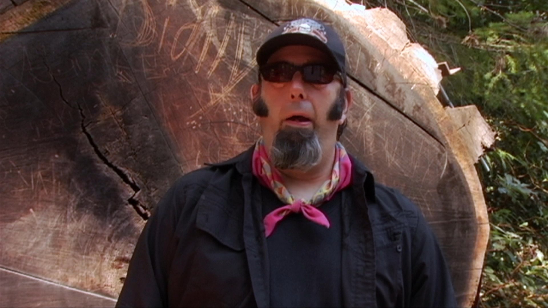A group of motorcyclists cruises down a scenic, sun-dappled road lined with trees. The segment then transitions to an interview with folk singer Steve "Beatnik" Werner.