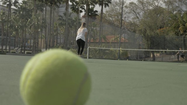 Playing tennis on a court