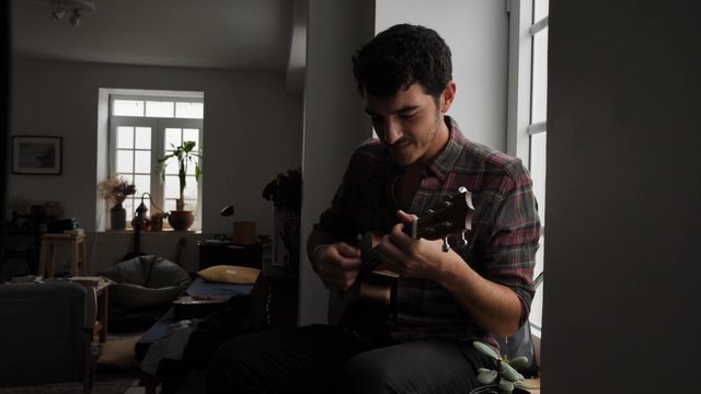 Playing the ukulele on a windowsill