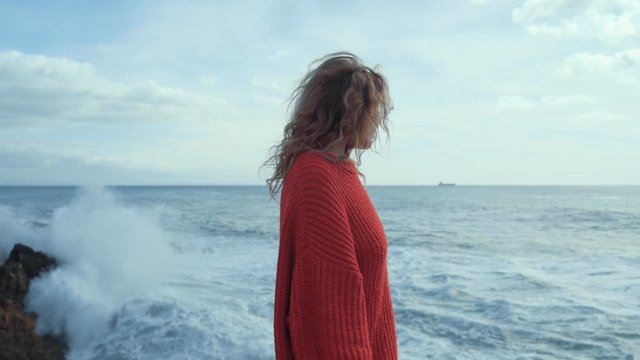 A young woman watching the waves