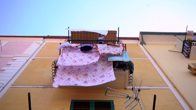 Woman hanging clothes on balcony