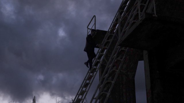 Man in suit climbing down a ladder