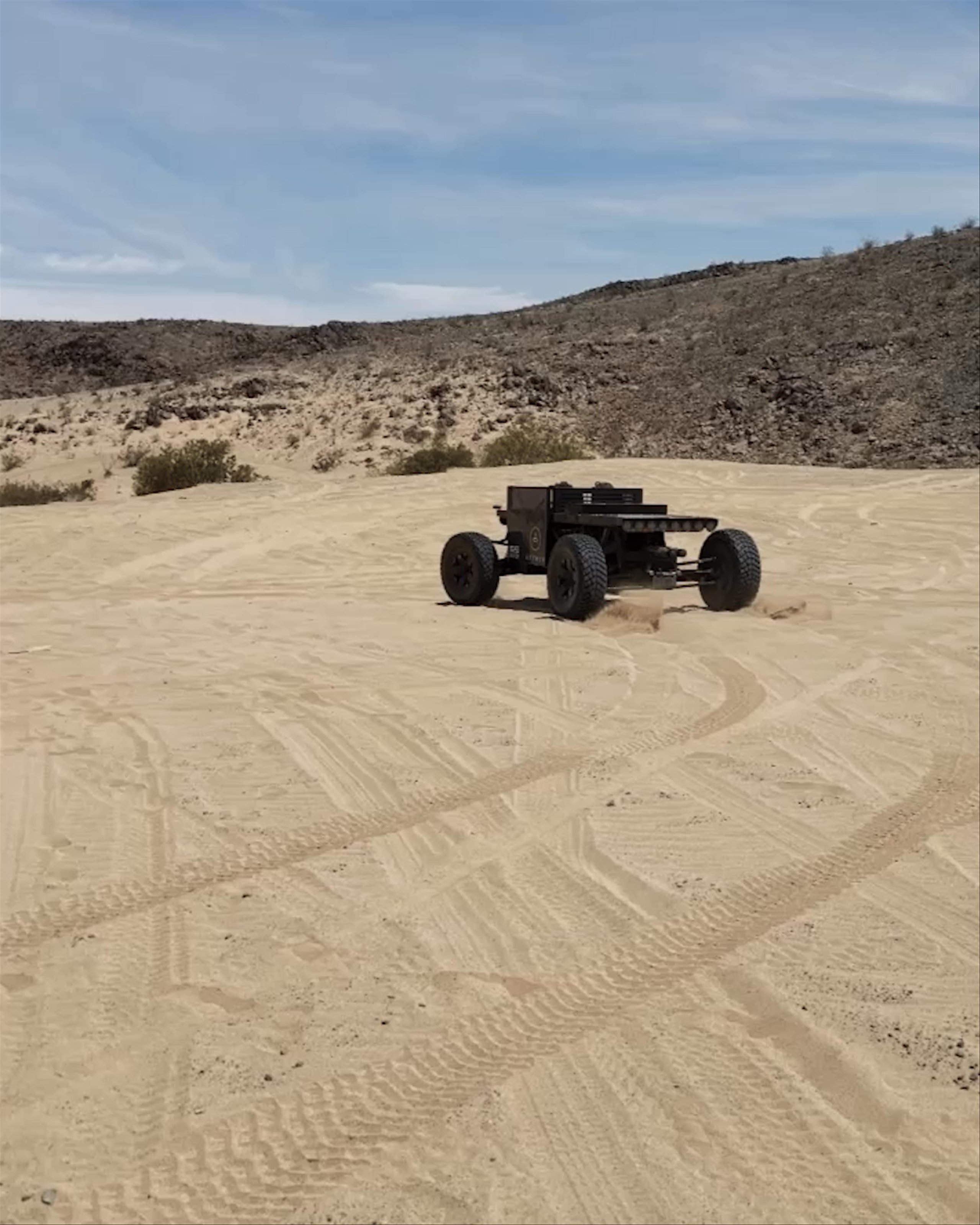 Video of custom black vehicle driving through desert landscape