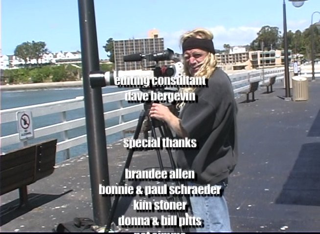 A surfer rides waves in a wetsuit, followed by a sequence of production credits displayed over footage of a cameraman and a large ship in the harbor.