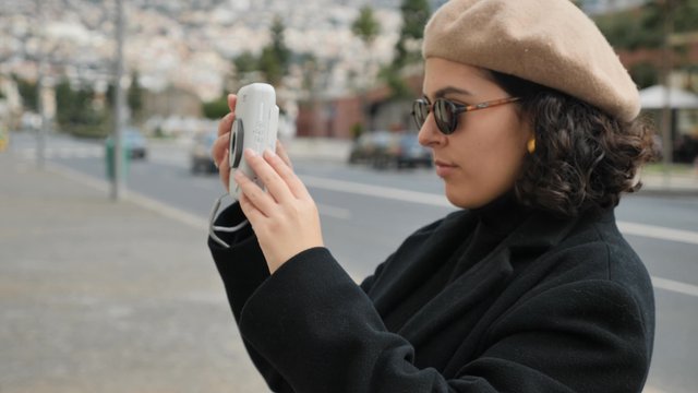 Woman taking photos with a modern Polaroid camera