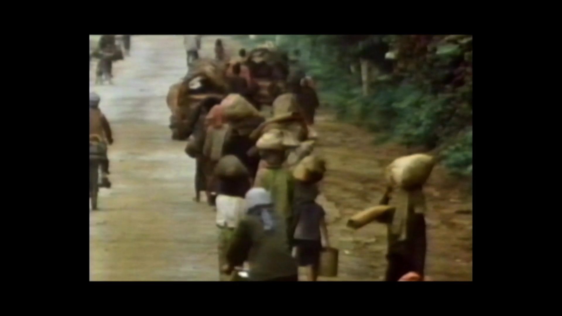 A man provides a firsthand account of witnessing families migrating and fleeing their homes. The narration is juxtaposed with archival footage of people walking along a rural path with their belongings.