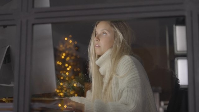 A woman working on her computer late at night