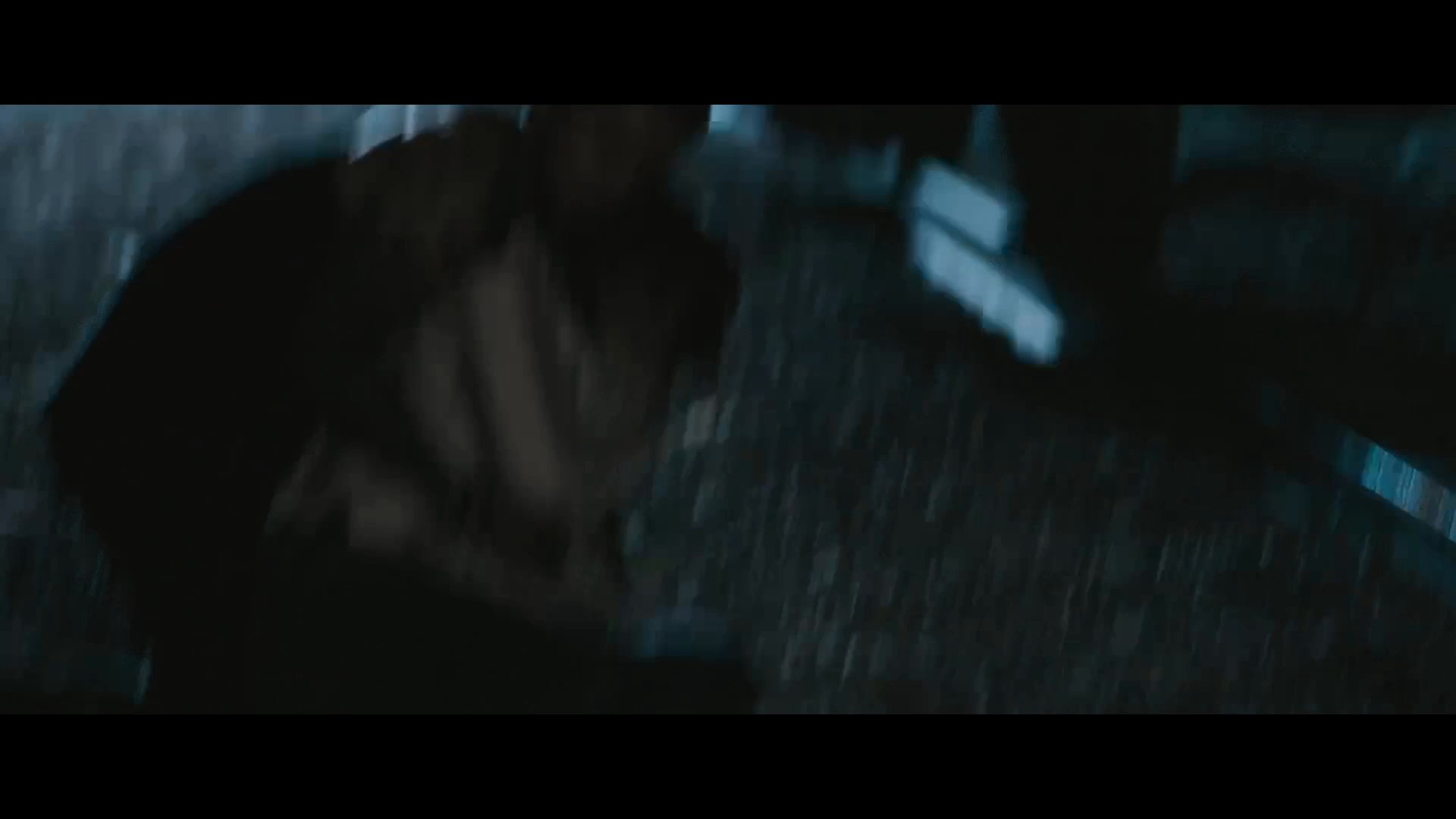 A man in a cowboy hat confronts and attacks another individual at night while others observe in fear. The aggressor subdues his target on the ground in a tense, violent standoff.