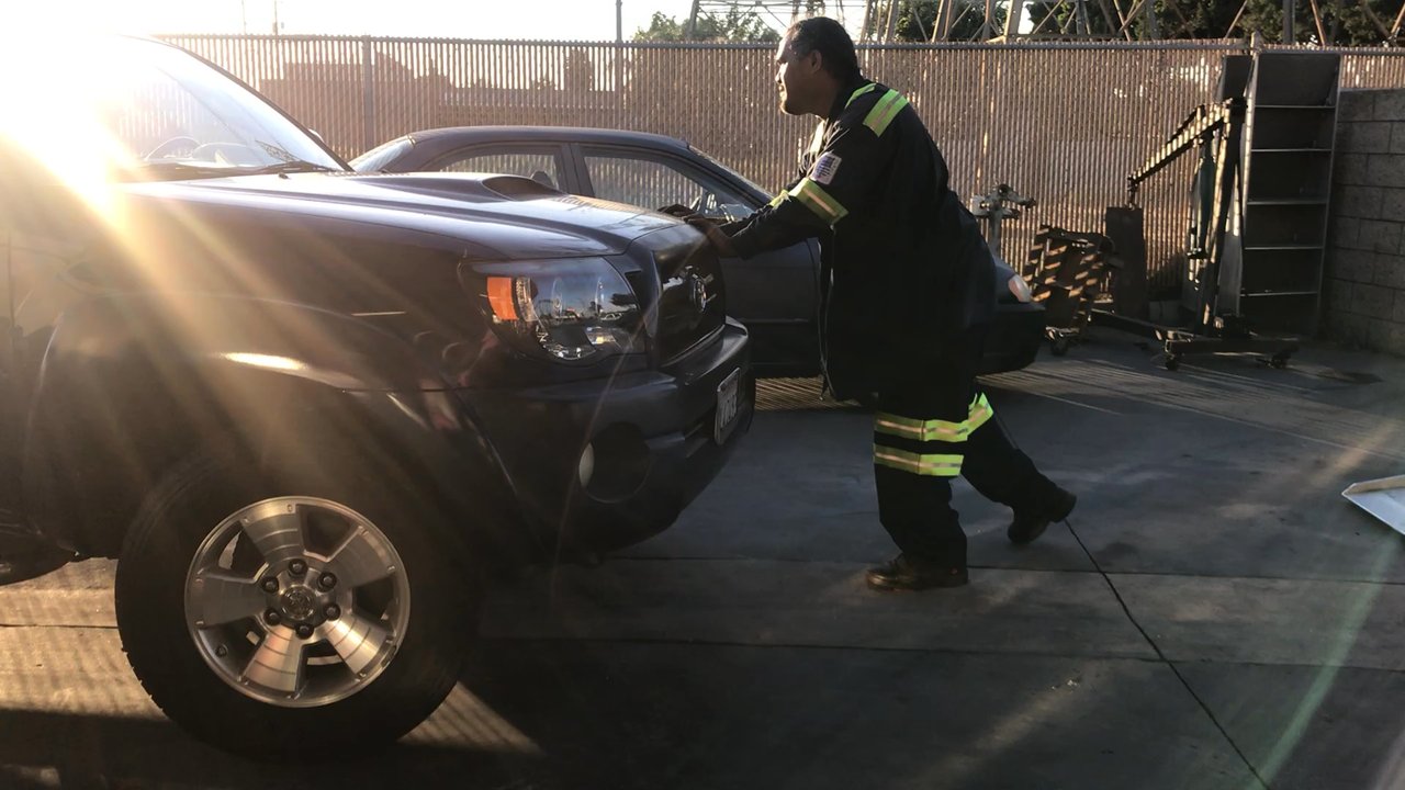A Checkered Towing - William pushing vehicle off tow truck at mechanics shop . Placing vehicle in a safe spot, he went the extra mile with a Happy attitude!! - Towing Near Me - Long Beach, California