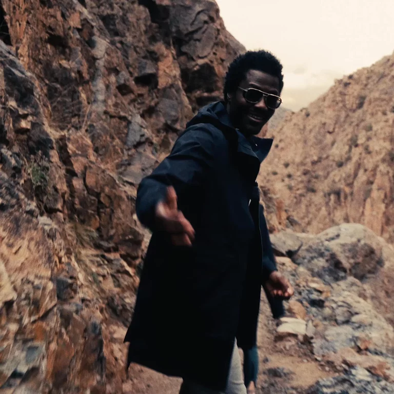 Video of man gesturing to come along on the rocky hike