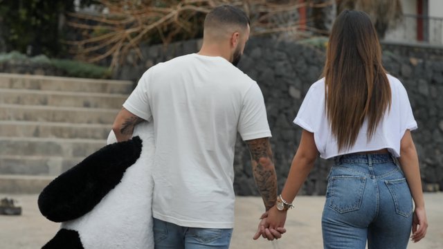 Couple walking with a panda toy