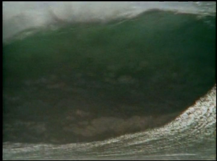 An experienced individual provides commentary on surfing, interspersed with dynamic footage of large, breaking ocean waves.