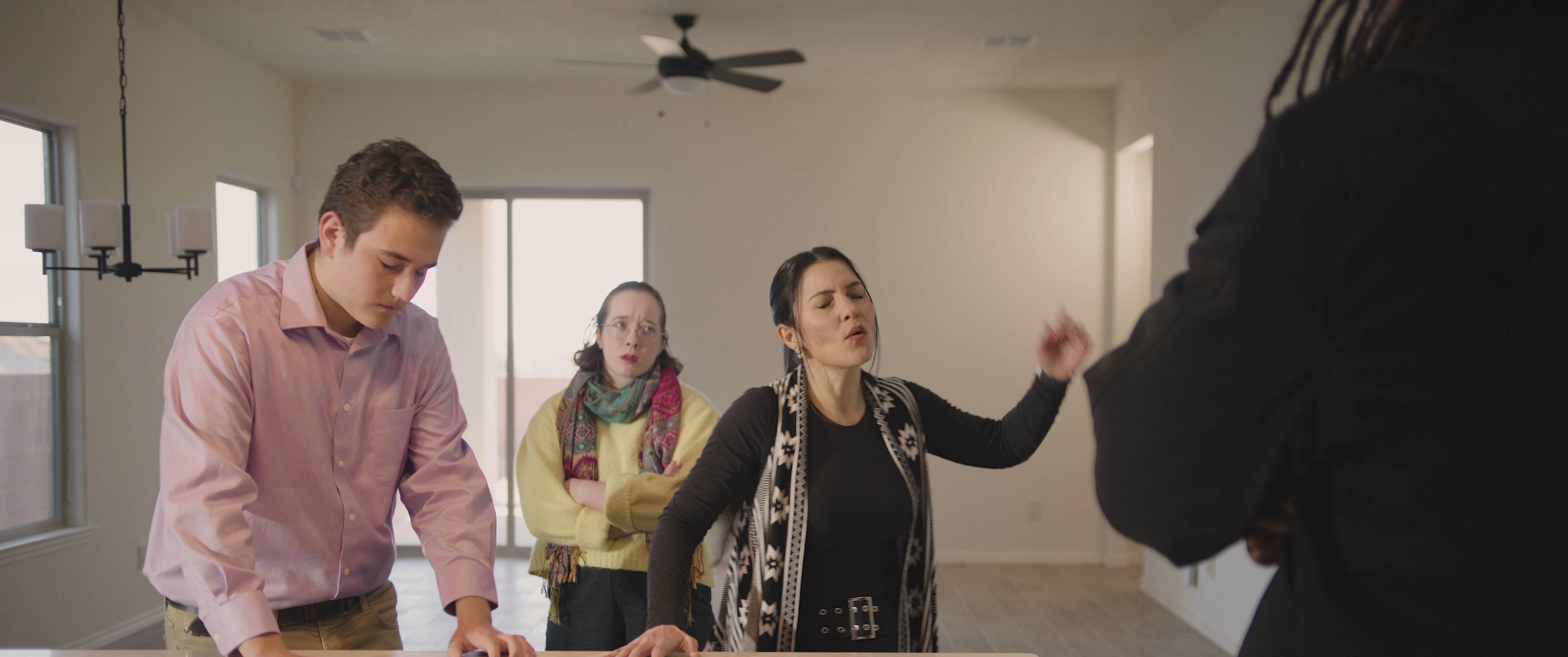 A group of individuals engages in a professional discussion with a contractor within a residential interior space. The group consults regarding property details, emphasizing collaborative decision-making.