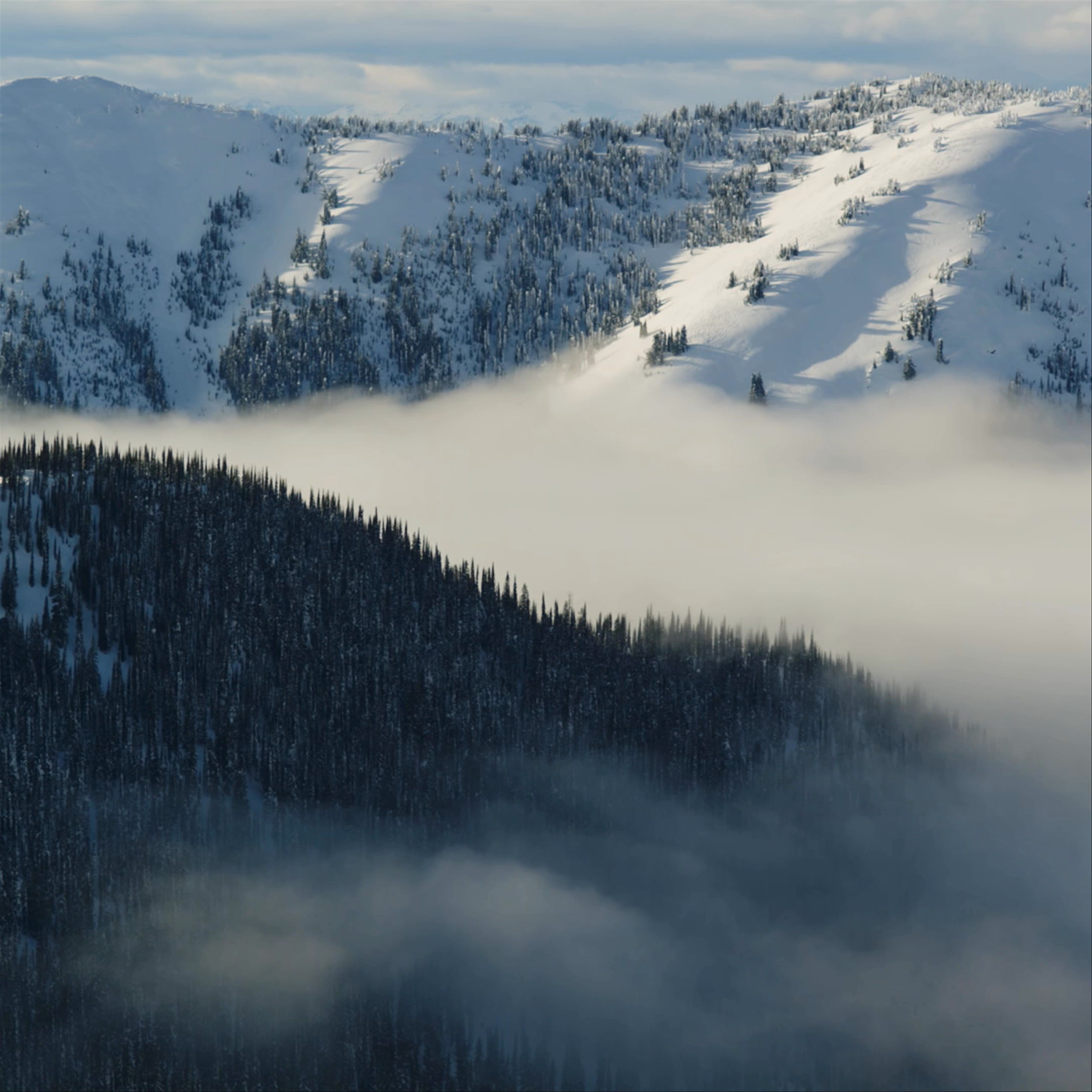Timelapse of fog rolling through snowy Alaskan mountains