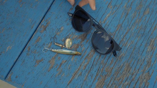 A fisherman putting sunglasses on