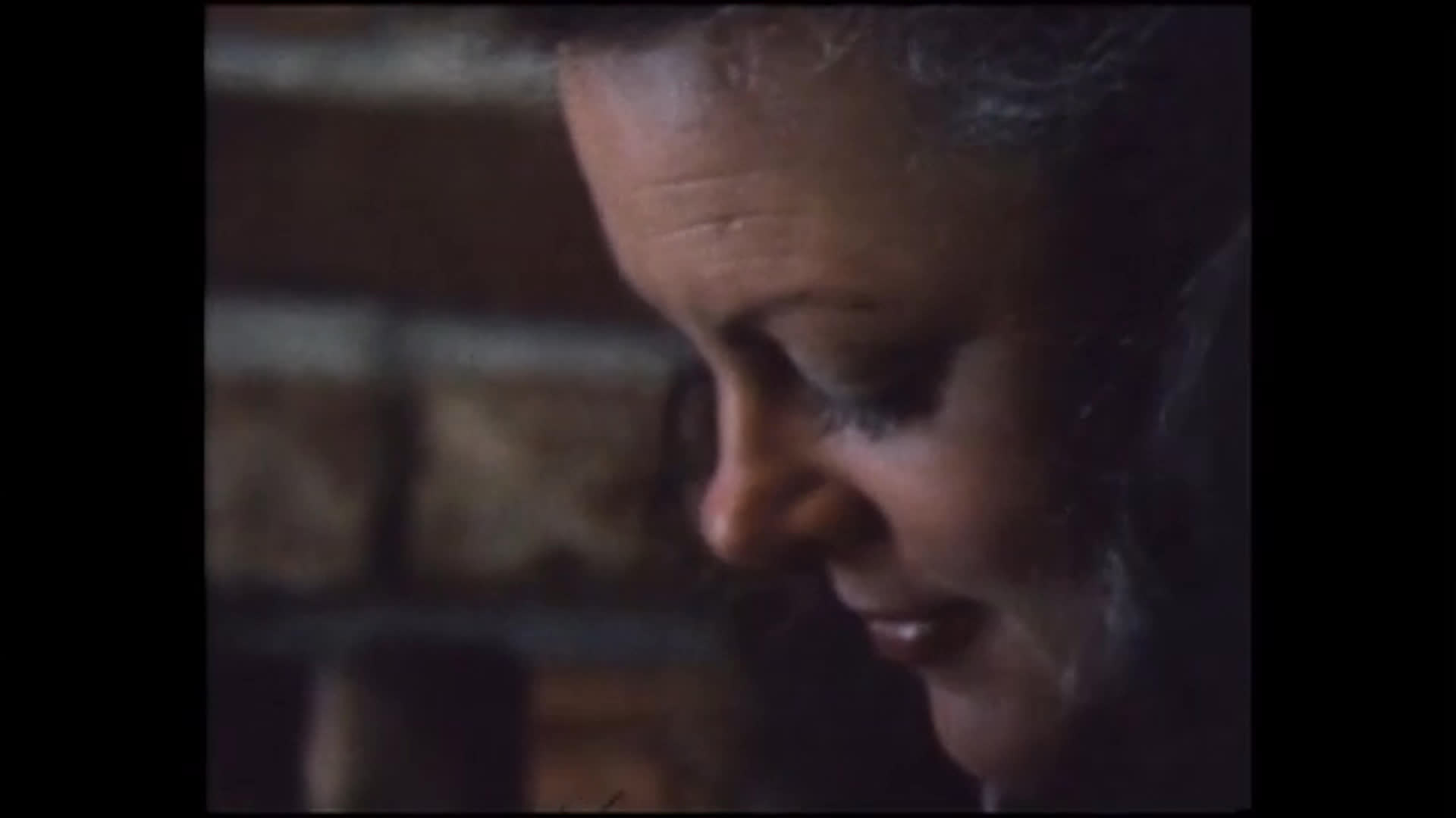 A woman gently tends to a young girl's hair as they discuss unfinished homework and her reluctance to go to school. The sequence shifts to a car traveling through a snowy landscape, where the child holds a drawing.
