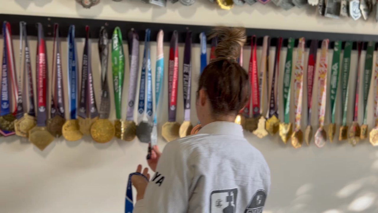 Evolve - Proudly placing their hard earned medal on the team wall ! - Muay Thai Near Me - Ladera Ranch, California