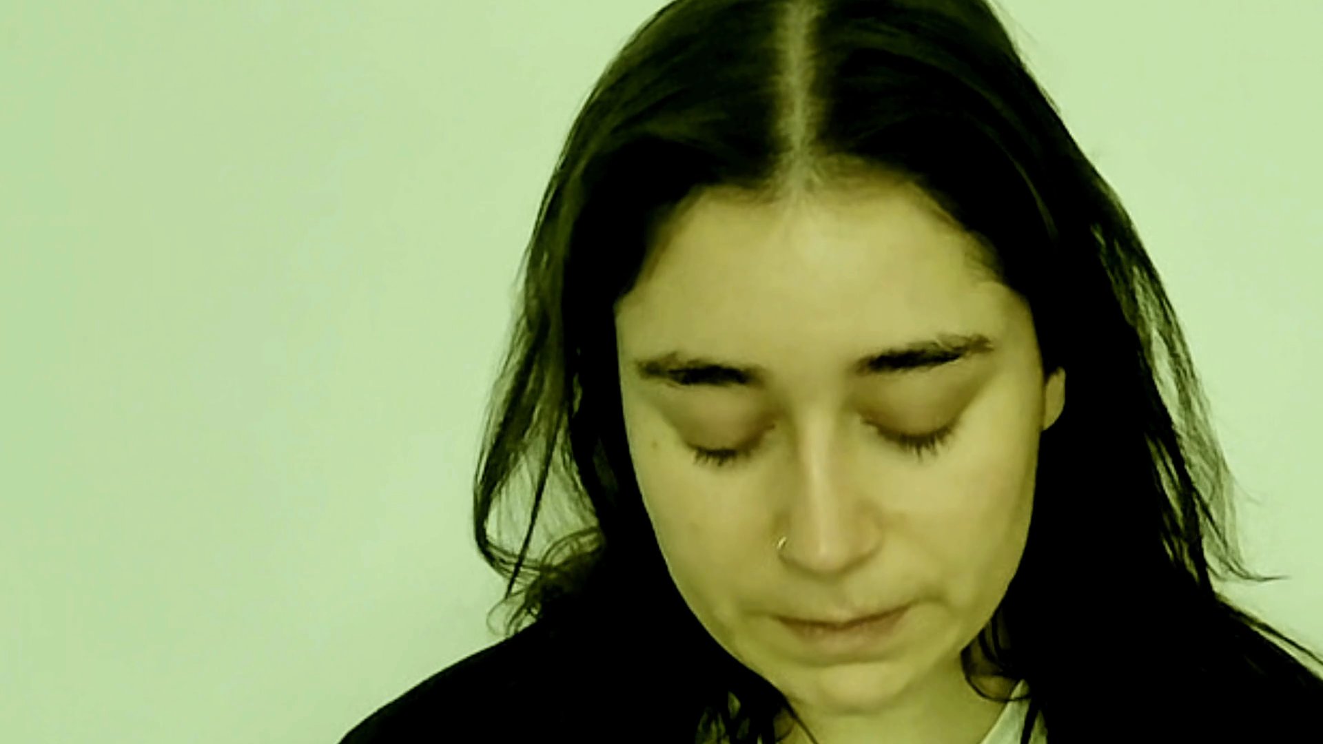 A woman speaks directly to the camera with varied, reflective facial expressions, conveying a thoughtful narrative.