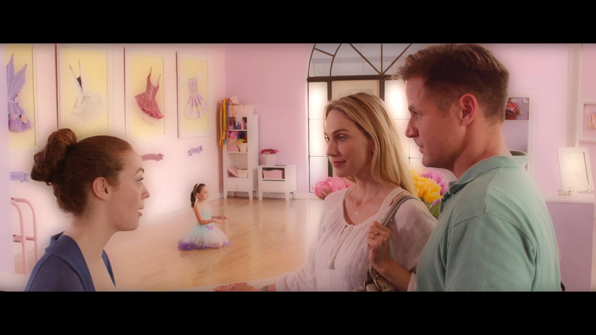 Parents observe their children practicing ballet in a bright dance studio while a professional instructor provides commentary on their progress.